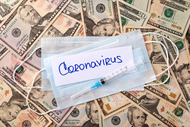istock Medical protective mask on dollars bills background, syringe 1220989546