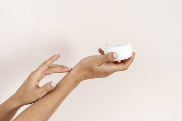 istock Woman with pampering cream touching soft skin on hands 1220990298