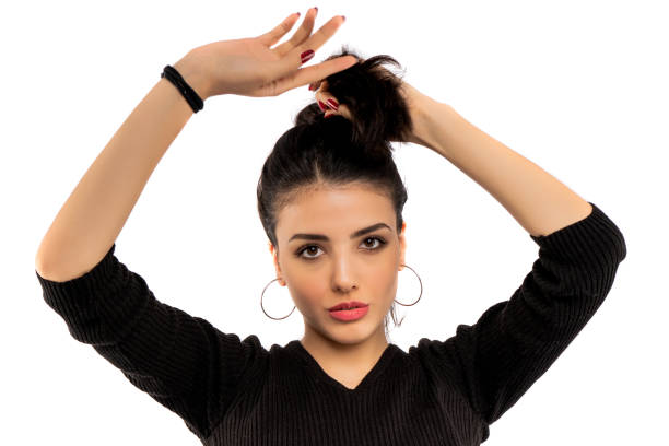 Brunette girl holding her black hair isolated on white background stock photo
