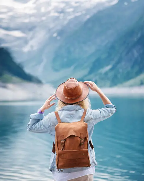 Photo of Travel image. Traveler look on the mountain lake. Travel and active life concept. Adventure and travel in the mountains region in the Austria.
