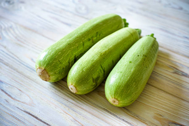 istock Fresh zucchini on wooden background. Top view. 1220990467