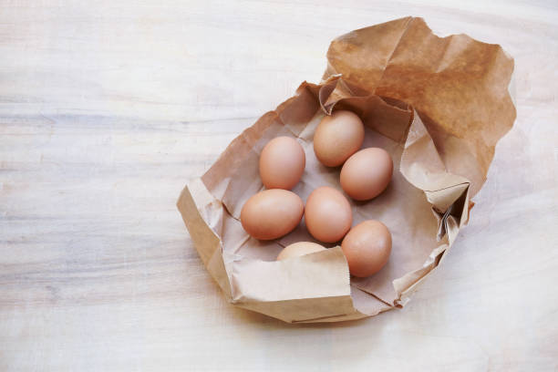 istock Brown egg in paper bag behind 1220993246