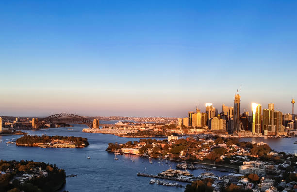 istock Panoramic drone aerial view over Sydney harbour on a cloudy sunset showing the nice colours of the harbour foreshore 1220993404