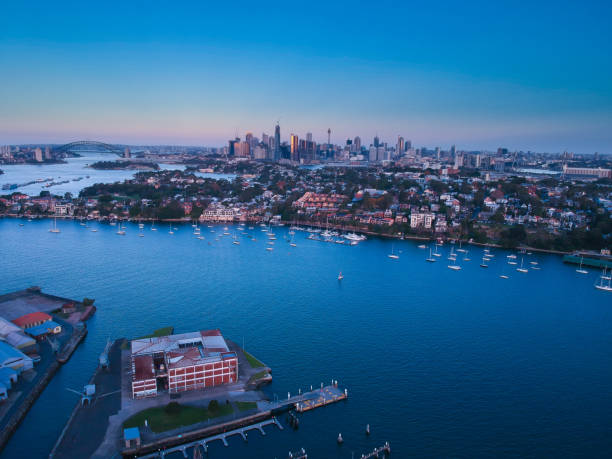 istock Panoramic drone aerial view over Sydney harbour on a cloudy sunset showing the nice colours of the harbour foreshore 1220993460