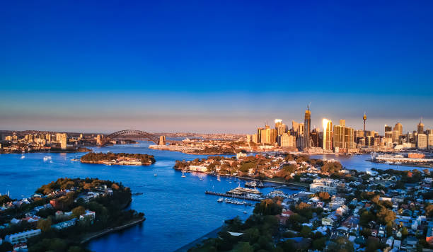 istock Panoramic drone aerial view over Sydney harbour on a cloudy sunset showing the nice colours of the harbour foreshore 1220993466