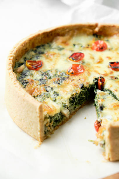 istock Homemade cheesy spinach quiche for brunch. set on white cafe table background. 1220994984