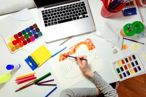 istock Child draws whale with watercolors using instructions on laptop. 1220995161