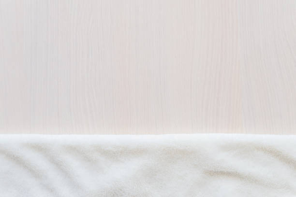 istock White delicate soft background of plush blancet fabric on biege white table. Mock up, copy space 1220995484