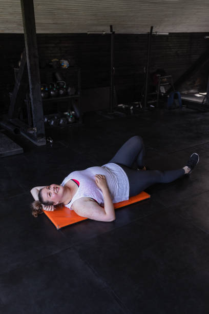istock Tired, but Happy: Smiling  plus size Woman Lying on the Floor after an Exhausting Workout 1220995629