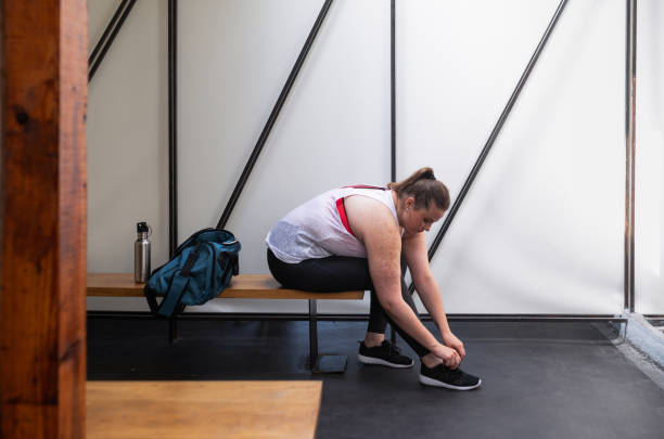 istock plus size Woman Tying Shoelaces on Sneakers before the Workout 1220995646