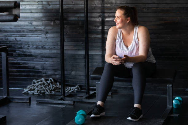 istock Happy plus size Woman Using her Smartphone at the Gym 1220995692