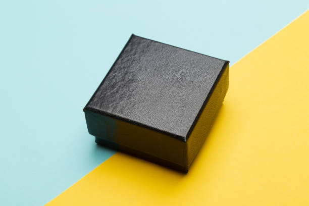 istock Mini black box product packaging isolated on yellow half blue background 1221000127