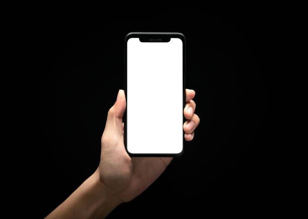 istock Male hand holding smartphone with blank screen at night over black background, Overwork and late work concept, Clipping path 1221000297