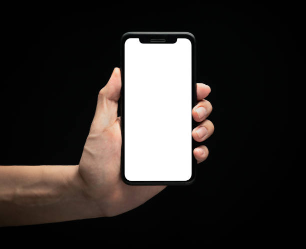 istock Male hand holding smartphone with blank screen at night over black background, Overwork and late work concept, Clipping path 1221000318