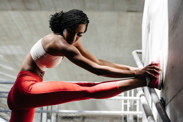 Portrait of African Sportswoman Stretching Her Leg Beautiful African sportswoman doing stretching exercise. stretched leg stock pictures, royalty-free photos & images