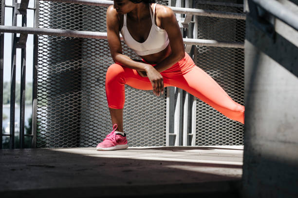 Fit Woman Doing the Side Lunge Exercise Pretty African woman doing a side lunge outdoors. lunge stock pictures, royalty-free photos & images