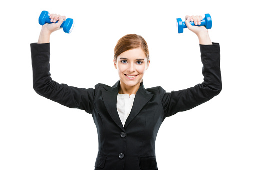 Beautiful and young business woman lifting weights and smiling, isolated over white background