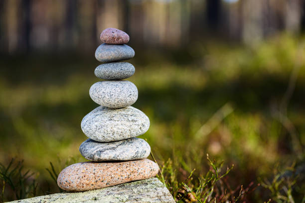 istock Pyramid stones balance on a stump in the forest. 1221005390