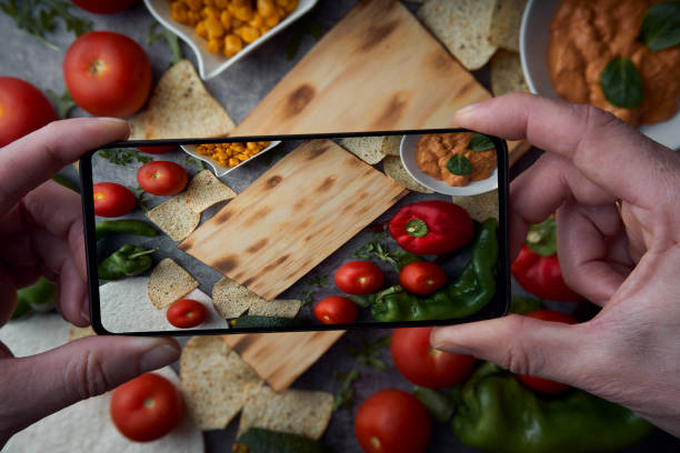 istock Man's hands taking photos with smartphone to a table preparing 1221005841