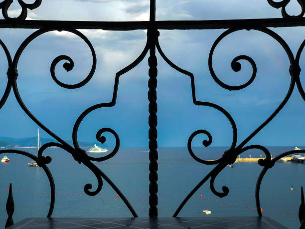 Beautiful view of the seaside visible through the ornamental parapet on a balcony.
