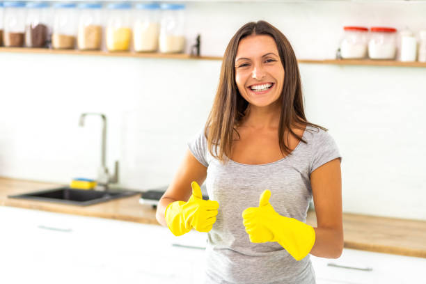 istock Determined wife in yellow gloves is ready and eager to start cleaning her modern kitchen and gives thumbs up. 1221009687