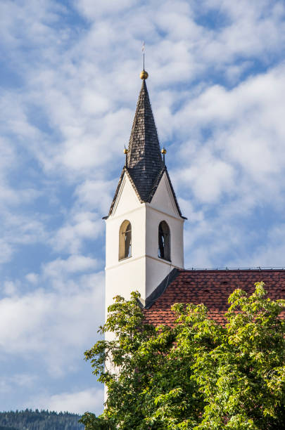 Clock tower with golden dials shining in the sunlight on the cathedral of St. Nicholas in Ljubljana, Slovenia.