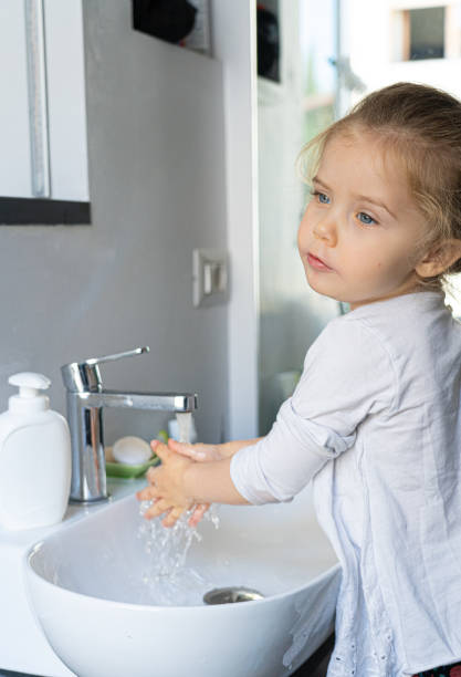 istock little girl washing her hands 1221012765