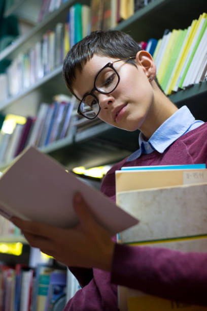 istock Young woman studying in the library 1221015355