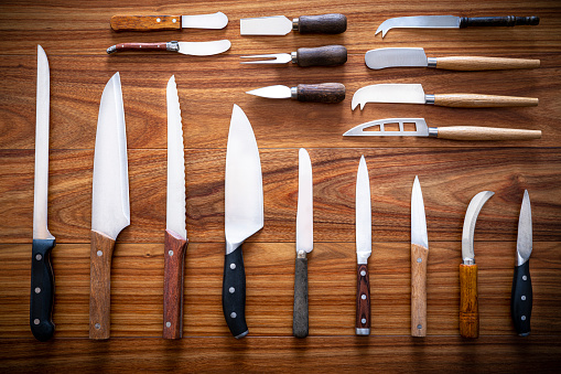 Inventario de cuchillos de cocina en backgroun de madera en una fila photo