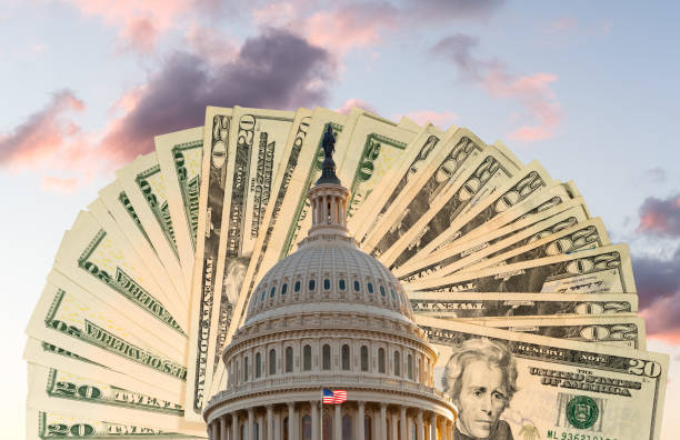 Flag flies in front of Capitol in DC with cash behind the dome as concept for stimulus virus payment US flag flies in front of the US Capitol in Washington DC with cash behind the dome to illustrate coronavirus stimulus payment federal building photos stock pictures, royalty-free photos & images