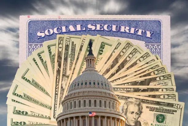 Photo of Flag flies in front of Capitol in DC with cash and social security card to illustrate funding issues for retirement