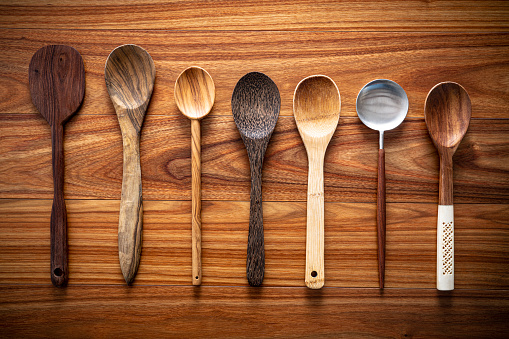Wooden spoon and spatula collencrtion inventory in a row on wooden background