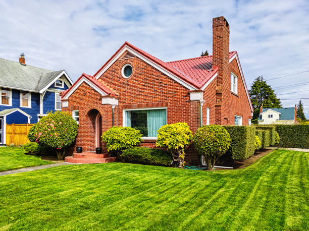Small Red Brick House with Green Grass Photo of a small American red brick home on a sunny day small stock pictures, royalty-free photos & images