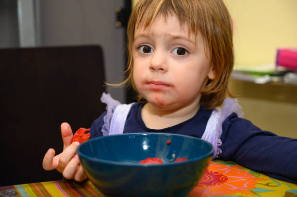 istock Girl eating strawberries 1221026038