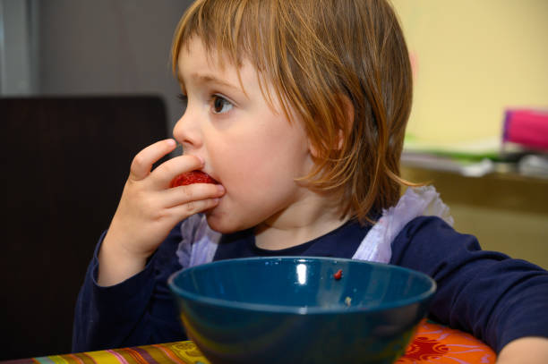 istock Girl eating strawberries 1221026157