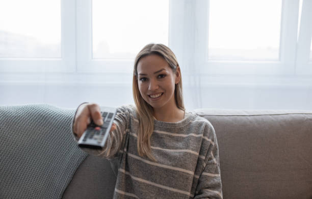 istock Girl holding a TV remote, changing the channel 1221027020