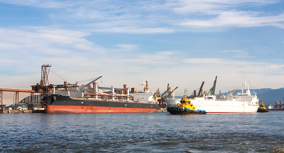Tanker being docked by tugboats in the port of Santos, Brazil.