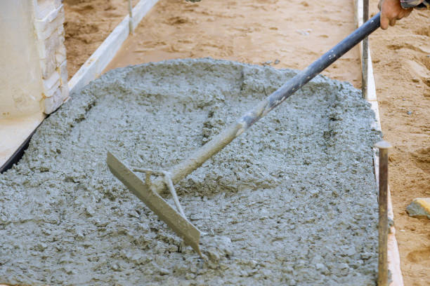 istock Construction workers leveling pavement concrete sidewalk in new residential home 1221027209