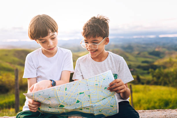 istock Two kids looking at map outdoors 1221029336