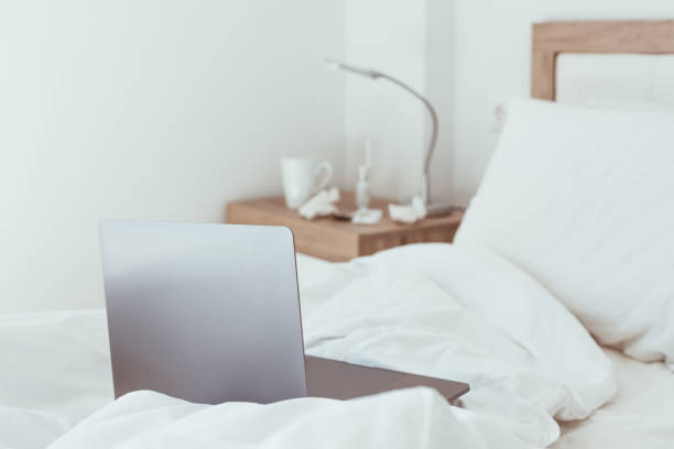 istock Working home isolation concept. Laptop in bed 1221030368
