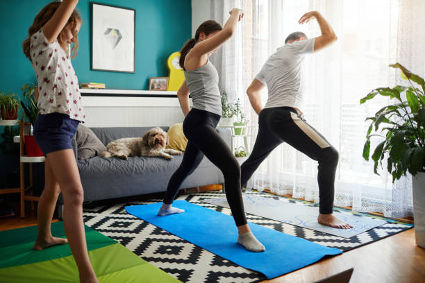 istock Family Practicing Yoga At Home With Online Classes 1221031770