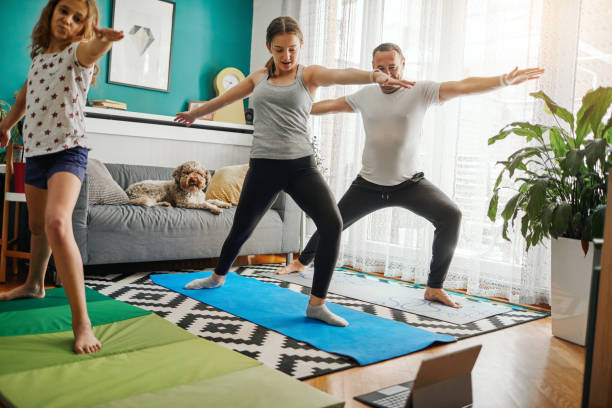 istock Family Practicing Yoga At Home With Online Classes 1221031783