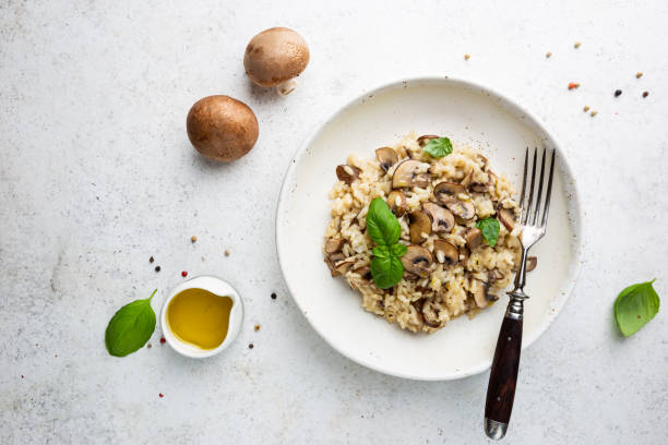 Risotto with mushrooms in a plate Risotto with mushrooms in a white plate over white background, top view porcini mushroom stock pictures, royalty-free photos & images