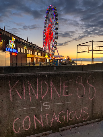 Seattle, USA – April 18, 2020: Late in the day the iconic Miners Landing on the waterfront completely empty at the height of the Coronavirus city wide shutdown. With a positive message in chalk.