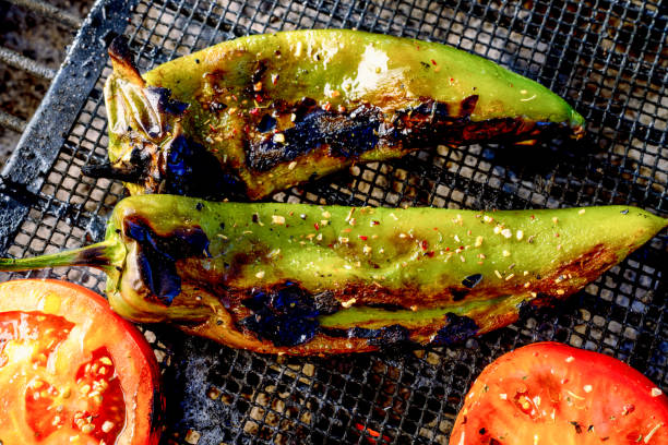 A Close Up Of Fresh Anaheim Chili Peppers Being Roasted Over A Charcoal Grill A charcoal grill with fresh chili peppers roasting on a charcoal grill anaheim pepper photos stock pictures, royalty-free photos & images