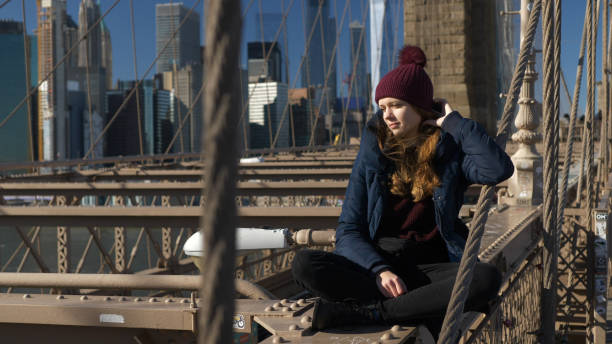 istock Beautiful girl on Brooklyn Bridge enjoys a sunny day while relaxing 1221035002