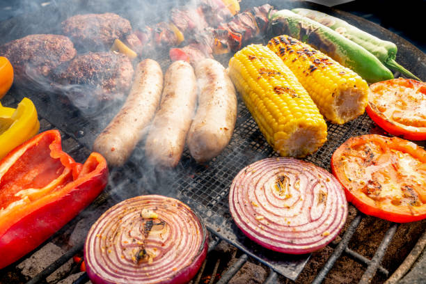 A Beautiful Mixed Grill Meat And Fresh Vegetables Arranged On A Charcoal Grill Peppers, Green Chilis, Corn, Onion, Hamburgers, Brats, and Kabobs arranged on a charcoal grill ketogenic diet photos stock pictures, royalty-free photos & images
