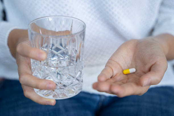 istock person taking a medical pill 1221036195