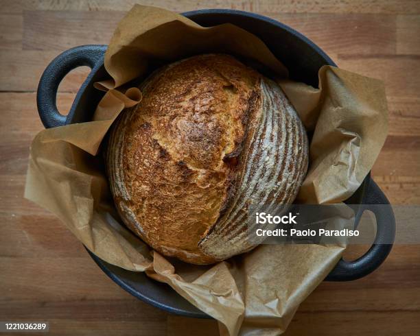 Homemade Sourdough Bread In A Dutch Oven On A Wooden Board Stock Photo - Download Image Now