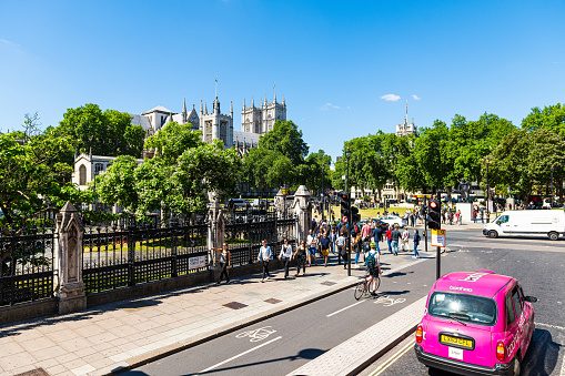 London, UK - June 22, 2018: Westminster Abbey with square and people by Crimea and Indian Mutiny monument and sidewalk on Bridge Street and Boohoo car